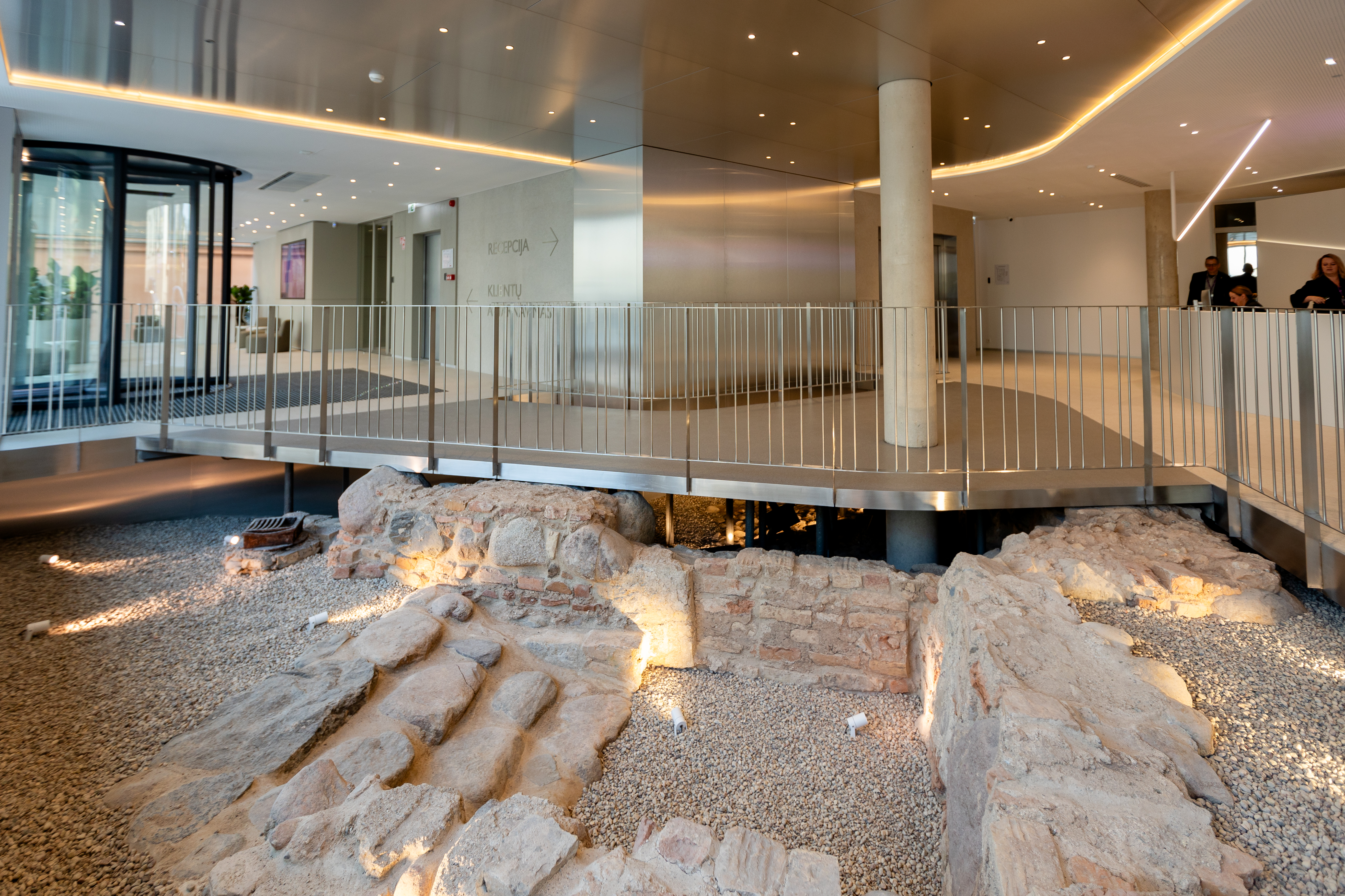 „Lietuvos draudimo“ centrinio biuro vestibiulis su išsaugotais archeologiniais mūro fragmentais.