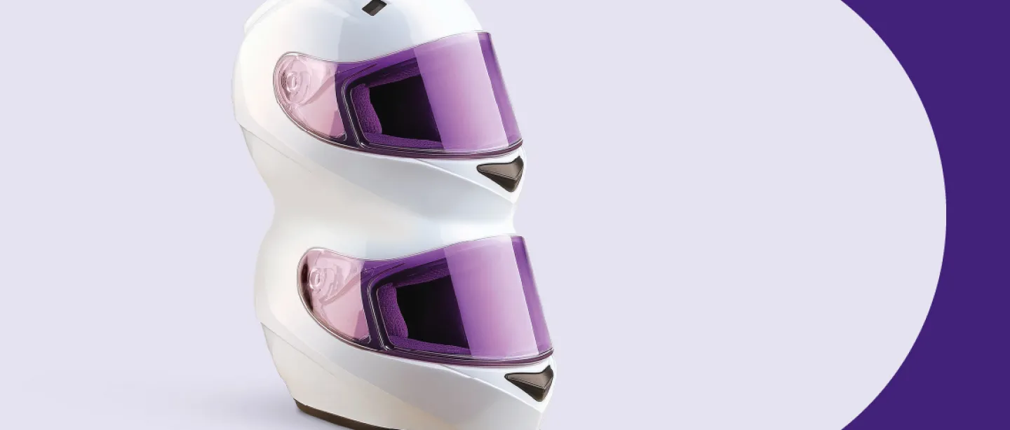 Violetinis fones, kuriame vienas ant kito sudėti du motociklininko šalmai.